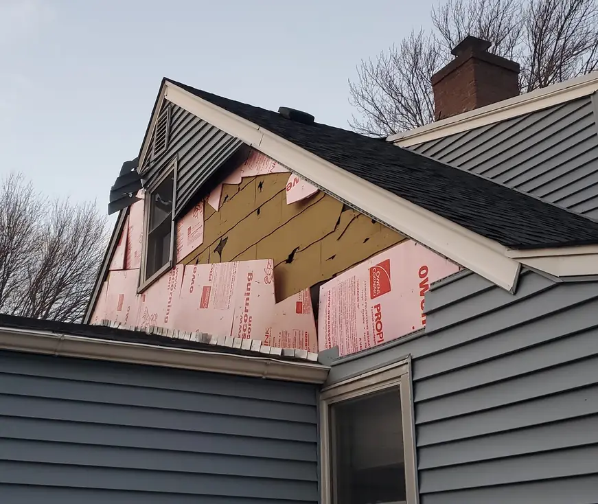 An Aronson crew mid tear off, with insulation board exposed across the elevation before new siding goes on