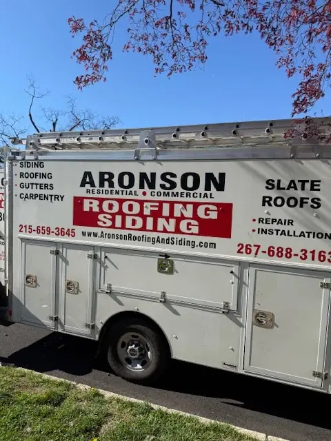 The Aronson work truck, signwritten Residential and Commercial, Roofing and Siding, with the phone number on the panel